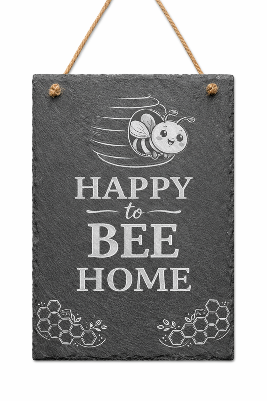 Portrait-oriented slate sign engraved with the words "Happy to BEE Home" and a cartoon image of a bee and honeycomb design accents